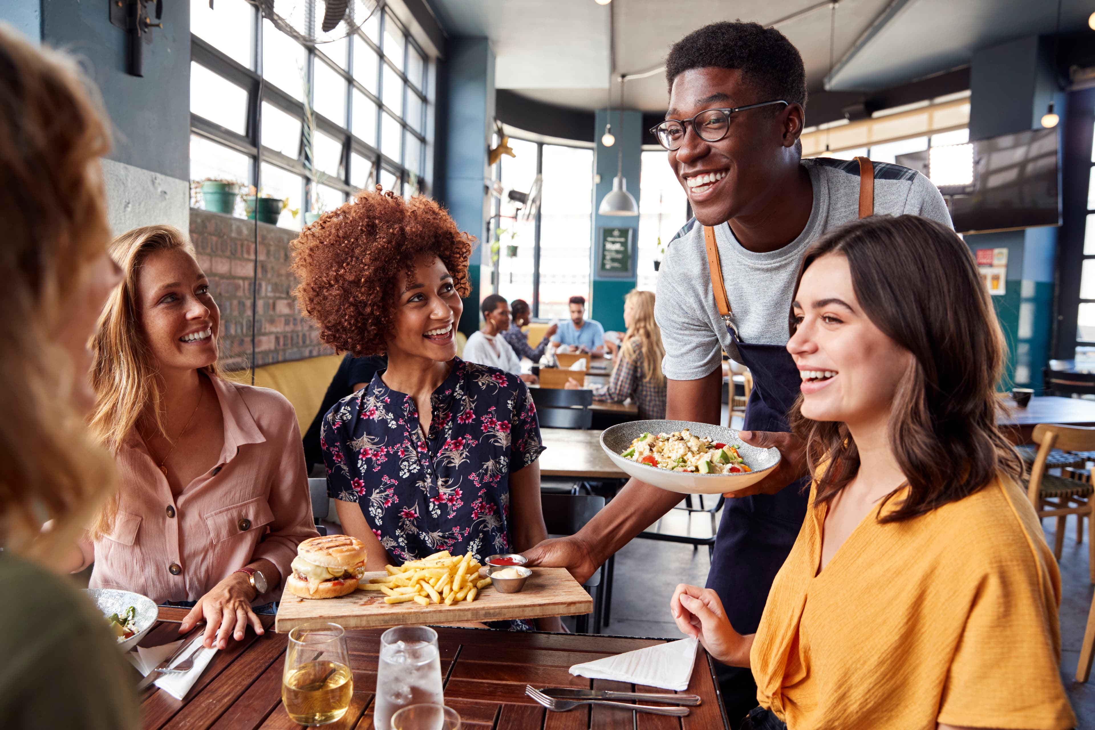 Waiter serving a group of friends at a restaurant
